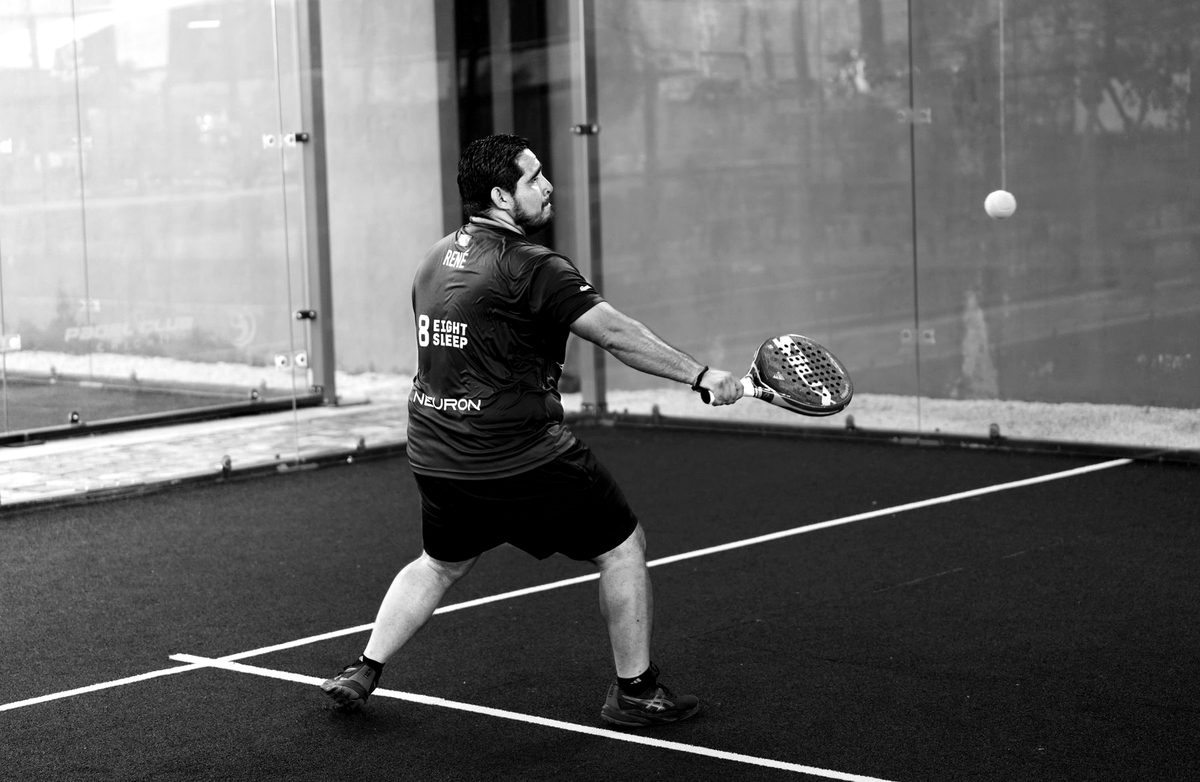 A player reaching for a shot on an indoor court